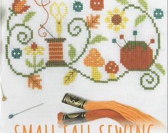 May include: A cross-stitch pattern titled "tinymodernist cross stitch" with the words "SMALL FALL SEWING" in orange. The design features fall-themed cross-stitch elements, including flowers, leaves, and a spool of thread. Two orange thread spools are in the foreground.