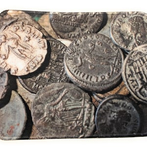 May include: A close-up image of a pile of ancient Roman coins. The coins are made of bronze and silver and have various designs and inscriptions.