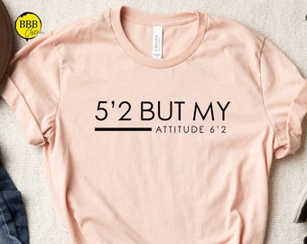 May include: A light pink t-shirt with the text "5'2 But My Attitude 6'2" printed in black.