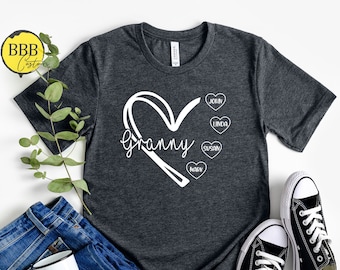 May include: A dark grey t-shirt with a white heart design that says "Granny" and has smaller hearts with the names John, Linda, Susan, and Kathy inside.