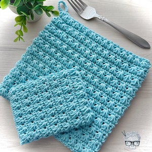 May include: Two crocheted pot holders in a light blue color. The larger pot holder has a loop for hanging.