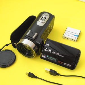 Può includere: Una videocamera digitale nera con copriobiettivo, batteria ricaricabile e cavo USB. Lo schermo ribaltabile mostra il testo IR, 2.7K, 2688 x 1520P High Definition e 30.0 Mega Pixels.