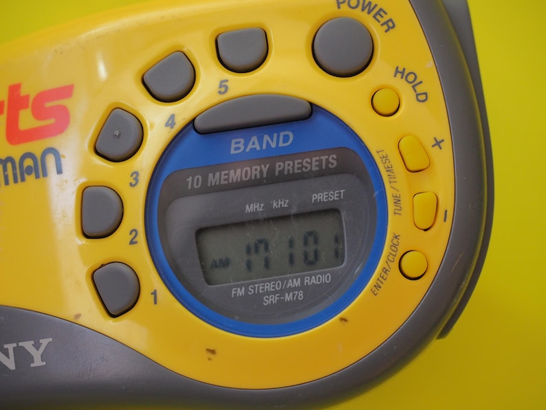 Puede incluir: Radio Sony Sports Walkman SRF-M78 amarilla y gris con pantalla digital que muestra la hora. Incluye botones preestablecidos, selector de banda y botones de encendido y retenci&oacute;n. Dise&ntilde;o retro.