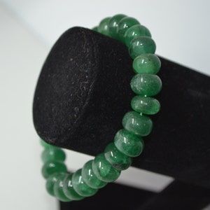 May include: A green jade beaded bracelet with smooth, rounded beads.