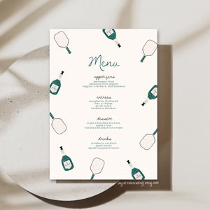 May include: A white menu with a teal green border and a teal green paddle design. The menu lists appetizers, entrees, dessert, and drinks. The text "Menu" is written in cursive.