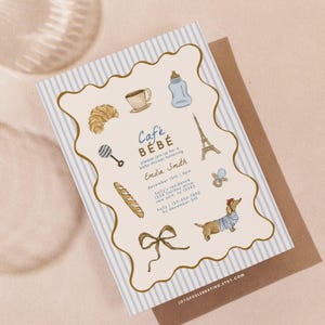 May include: A baby shower invitation with a blue and white striped border and illustrations of a croissant, coffee cup, baby bottle, Eiffel Tower, and a dachshund. The invitation reads "Café Bébé" and includes event details.