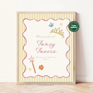 May include: A framed sign with a cream background and pink and gold accents. The sign reads "Fancy Favors" with illustrations of a crown, butterfly, star, flower, and wand. The sign also includes the text "Please grab one!" and "Thank you for celebrating with me!"