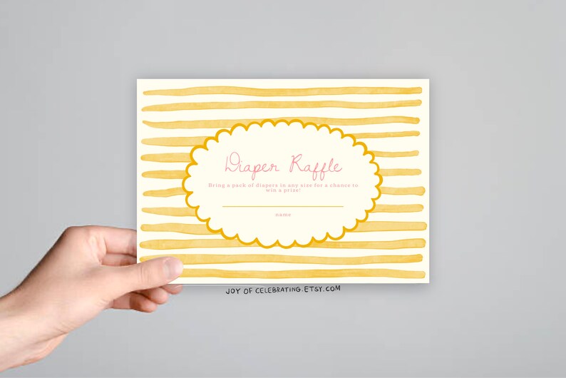 May include: A yellow and white striped card with a scalloped circle in the center. The circle says "Diaper Raffle" in pink lettering and "Bring a pack of diapers in any size for a chance to win a prize." The bottom of the card says "JOY OF CELEBRATING. ETSY.COM".