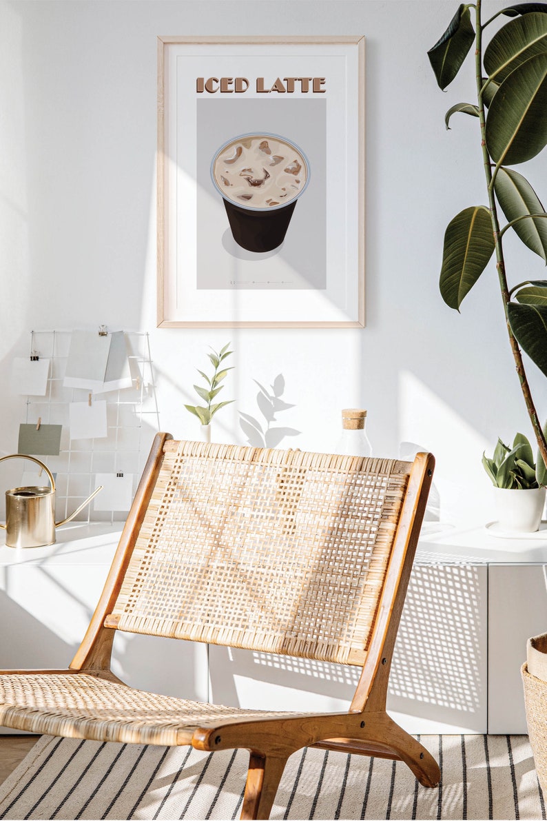 May include: A framed print of a minimalist illustration of an iced latte in a to-go cup. The text "ICED LATTE" is printed in brown letters at the top of the print.
