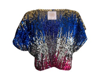 May include: A sequined top with a V-neck design. The top features a gradient of colors, starting with gold at the shoulders, transitioning to blue, silver, and ending with pink at the bottom. The top has short sleeves and a small label.