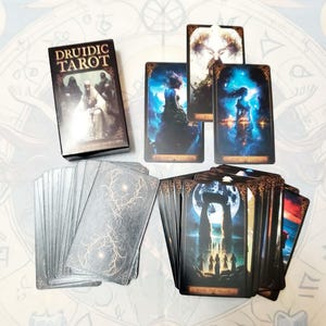 May include: A Druidic Tarot deck featuring a black box with gold text, alongside several illustrated cards. The cards display dark, atmospheric imagery including figures, celestial scenes, and a stone monument under a full moon.