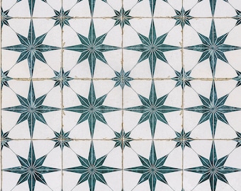 May include: A white tiled floor with a repeating pattern of dark teal eight-pointed stars.