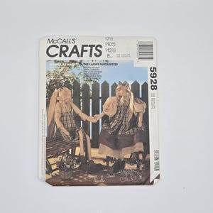 May include: A McCall's Crafts pattern envelope featuring whimsical rabbit dolls. The cover displays illustrations of the dolls, a seated rabbit and a standing rabbit, with text including "Never a Dull Needle".