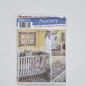 May include: A Simplicity Home Decorating pattern for nursery accessories. The package features a crib with bedding, a wall hanging, and a chenille rug. The text on the package reads "Nursery The ABC's of Nursery Accessories."