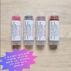Puede incluir: Cuatro b&aacute;lsamos labiales con etiquetas que dicen "Rose", "Cocoa", "Wine" y "Red". Las etiquetas tambi&eacute;n enumeran ingredientes como cera de abejas, menta y aceites esenciales. La imagen incluye texto que dice "I also make this with SPF 15! Find it on my shop."