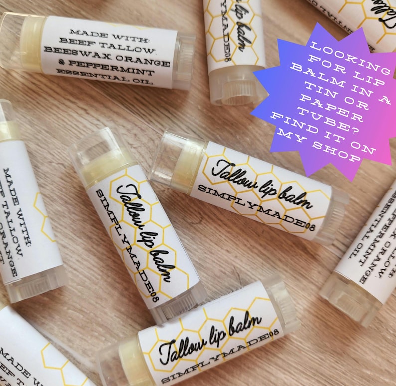 Puede incluir: Varios tubos de b&aacute;lsamo labial con la etiqueta "Tallow lip balm SIMPLYMADE08". Los tubos transparentes contienen un b&aacute;lsamo amarillo p&aacute;lido. Ingredientes: sebo de res, cera de abejas, naranja y aceite esencial de menta. El texto "Looking for lip balm in a tin or paper tube? Find it on my shop."