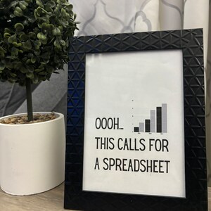 May include: A black framed print with a white background and a black and gray bar graph. The text "OOOOH... THIS CALLS FOR A SPREADSHEET" is printed below the graph.
