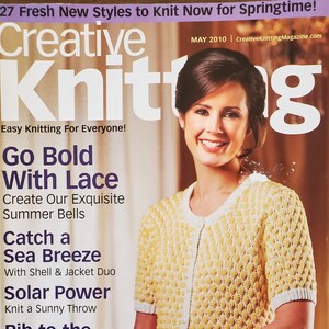 May include: A magazine cover for Creative Knitting magazine, featuring a woman wearing a yellow and white knitted cardigan. The cover text reads "Go Bold With Lace", "Create Our Exquisite Summer Bells", "Catch a Sea Breeze", "Solar Power", "Knit a Sunny Throw", "Rib to the Ruffles", "Update a Classic", and "Banana Cream Cardi, page 46".