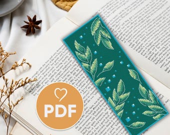 May include: A teal blue bookmark with a cross-stitch pattern of green leaves and light blue squares. The bookmark has the word "PDF" in a heart shape on it.