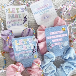 May include: A collection of colorful scrunchies in pink, blue, and purple, each adorned with beaded bracelets and personalized tags. The tags read "LET'S PARTY" and "THANK YOU FOR CELEBRATING WITH ME!" with additional text for a 13th birthday.
