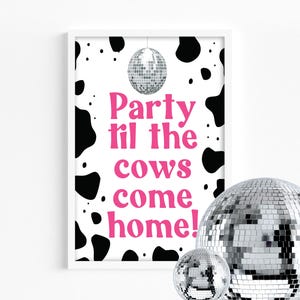 Puede incluir: Una impresión enmarcada con un fondo blanco y manchas negras de vaca. El texto "Party til the cows come home!" está en rosa. Una bola de discoteca plateada cuelga de la parte superior y dos bolas de discoteca están en primer plano.