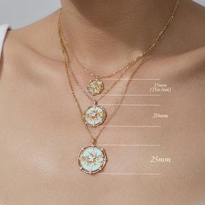 K&ouml;nnte beinhalten: Drei goldfarbene Halsketten mit runden Anh&auml;ngern, die ein Sternmotiv und eine hellblaue Emaille-Einlage aufweisen. Die Anh&auml;nger sind mit Gr&ouml;&szlig;en von 15mm, 20mm und 25mm beschriftet, wobei die 15mm-Gr&ouml;&szlig;e als dieser Link f&uuml;r das Produkt markiert ist.