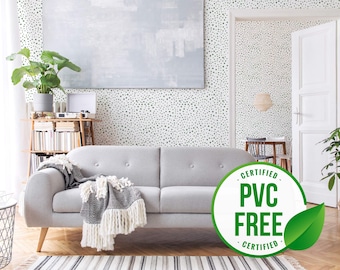 Puede incluir: Una sala de estar con un sofá gris y una pared blanca con un patrón de lunares negros y blancos. La pared está decorada con una pintura grande y una planta. Una pegatina verde y blanca con el texto "CERTIFICADO LIBRE DE PVC CERTIFICADO" está en el suelo.