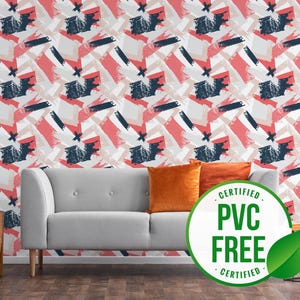 Puede incluir: Un sofá gris con cojines naranjas frente a una pared blanca con un patrón geométrico rosa, blanco y azul. Un logotipo de hoja verde con el texto "CERTIFIED PVC FREE CERTIFIED" está en primer plano.