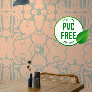 May include: A light pink and blue floral wallpaper with a wooden table and two chairs. The table has three small vases with dried flowers. A sign on the wall reads "CERTIFIED PVC FREE CERTIFIED".