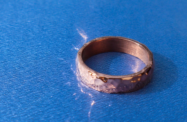 May include: A hammered gold-toned ring with a textured surface.