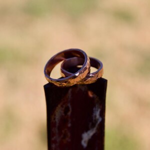 May include: Three gold-colored rings stacked on top of each other. The rings are textured and have a hammered finish.
