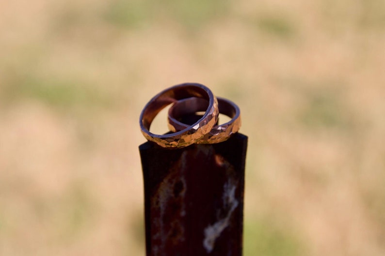 May include: Three gold-colored rings stacked on top of each other. The rings are textured and have a hammered finish.