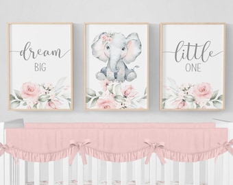 May include: A pink and white floral crib bedding set with a pink ruffled crib skirt and a pink and white floral crib sheet. Three framed prints with the text "dream big", "little one", and a watercolor illustration of an elephant with pink flowers.