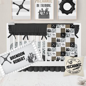May include: A black and white crib bedding set with a patchwork quilt featuring tools and a wrench design. The set includes a pillow with the text "Little Mechanic in Training" and a fitted sheet with a wrench design. The crib is decorated with three framed prints featuring tools and the text "Lil' Mechanic in Training".