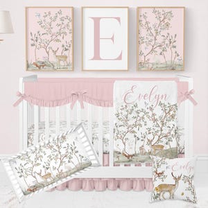 May include: A nursery set with a white crib, pink bedding, and framed art. The bedding features a woodland scene with deer and trees. The artwork includes a large letter "E" and matching nature-themed prints. The overall color scheme is soft pink and white.