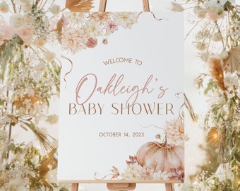 May include: A white sign with a floral border and a pumpkin design. The sign says "Welcome to Oakleigh's Baby Shower" and "October 14, 2023".