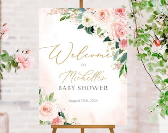 May include: Welcome to Michelle's Baby Shower sign with pink and white floral design. The sign is on an easel and has a gold script font. The date of the shower is August 17th, 2024.