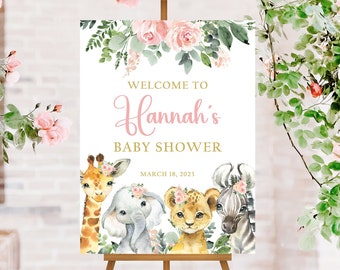 May include: A baby shower welcome sign on a wooden easel, featuring the text "Welcome to Hannah's Baby Shower" in pink and gold script. The sign includes watercolor illustrations of a giraffe, elephant, lion, and zebra. Floral accents and the date March 18, 2023 are also included.