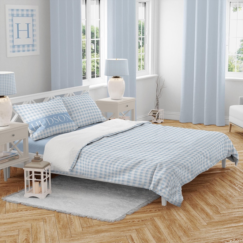 May include: A blue and white gingham bedding set with a pillow featuring the name "HUDSON".