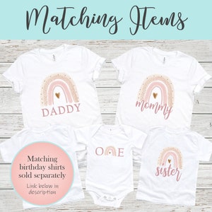 May include: Matching family shirts with a rainbow design. The shirts say "Daddy", "Mommy", "One", and "Sister".
