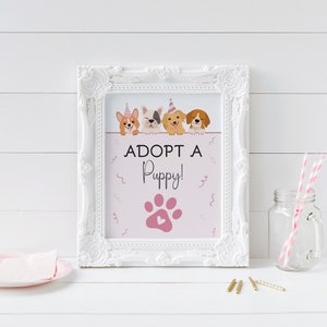 May include: A white framed sign with a pink background and the text "Adopt a Puppy!" with a pink paw print. Four cartoon dogs with party hats are peeking over the top of the sign.