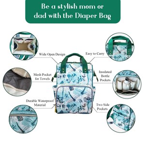 May include: A green and blue nappy bag with a dragonfly print. The bag has multiple pockets, including insulated bottle pockets, a mesh pocket for towels, and two side pockets. The bag has a wide open design and is easy to carry.