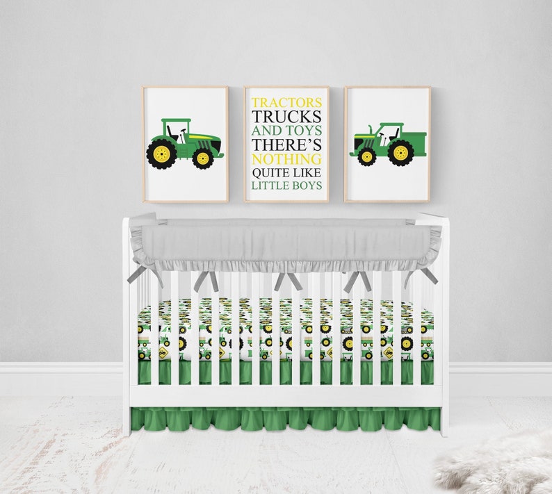 Pu&ograve; includere: Un lettino bianco con un set di biancheria da letto per lettino a stampa di trattore verde e bianco. Il lettino ha un volant grigio intorno alla parte superiore e un volant verde intorno alla parte inferiore. Ci sono due stampe incorniciate sul muro dietro il lettino. Una stampa presenta un trattore verde con il testo "Trattori Camion e Giocattoli Non c'&egrave; niente di meglio dei bambini piccoli". L'altra stampa presenta un trattore verde.