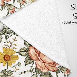 Op de afbeelding: Een wit fleece deken met een bloemenpatroon met gele, rode en groene bloemen. De achterkant van het deken is effen wit. De tekst "Single Sided (Solid white back)" is op het deken gedrukt.