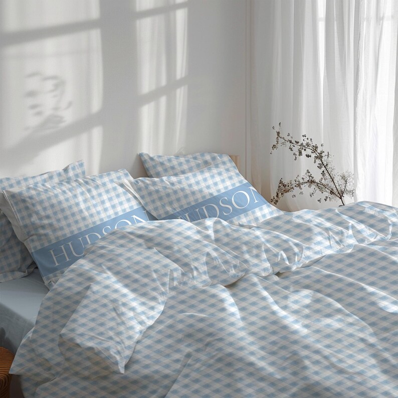 May include: A blue and white gingham bedding set with the name "HUDSON" printed on the pillowcases.