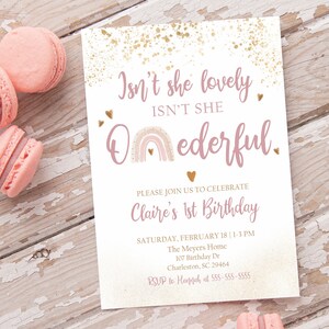 May include: A pink and gold first birthday invitation with a rainbow and the text "Isn't she lovely ISN'T SHE Onederful." The invitation includes the date, time, and location of the party.
