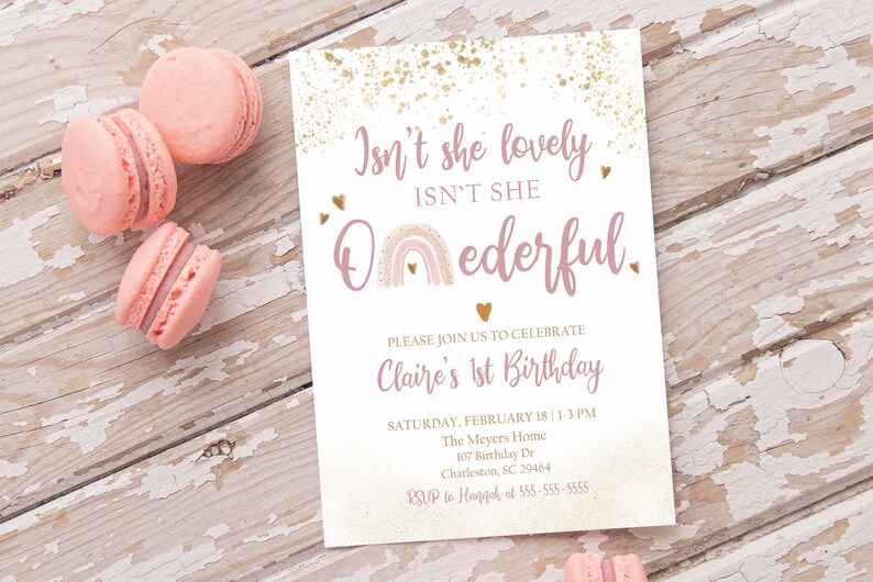 May include: A pink and gold first birthday invitation with a rainbow and the text "Isn't she lovely ISN'T SHE Onederful." The invitation includes the date, time, and location of the party.