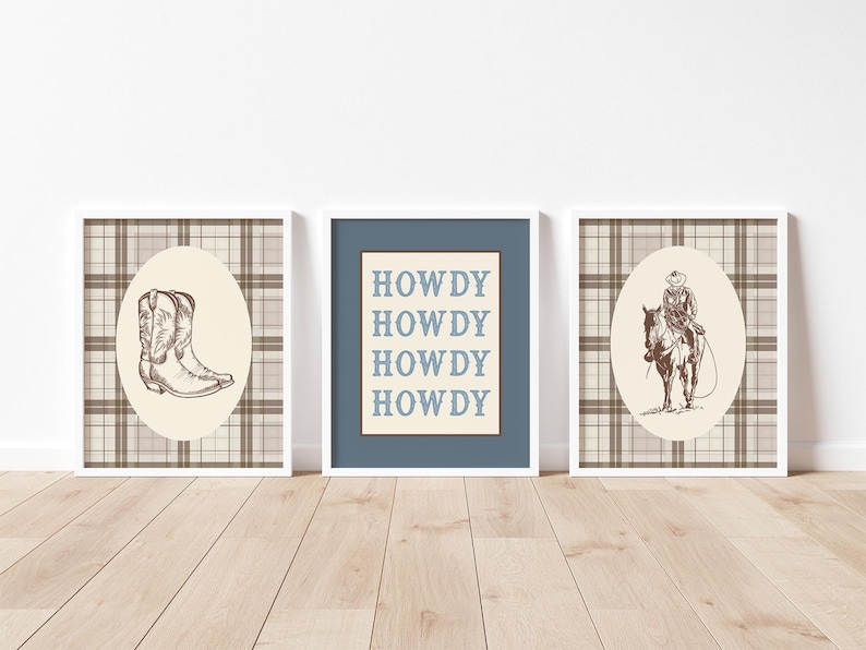 May include: Three framed prints with a Western theme. The prints feature a cowboy boot, the word "HOWDY" repeated, and a cowboy on horseback. Each print has a white frame and a plaid background.