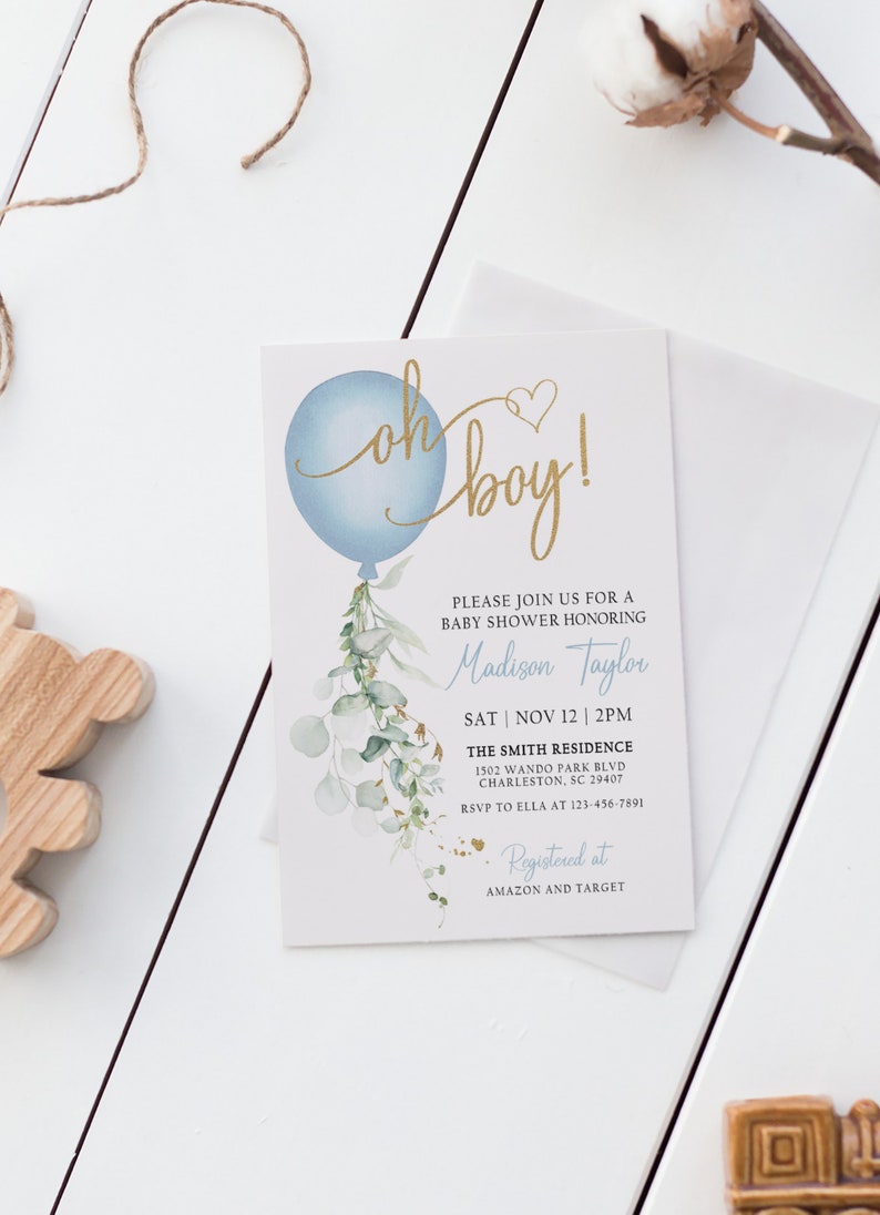 May include: A baby shower invitation with a blue balloon and gold lettering that says "Oh boy!" The invitation is decorated with watercolor greenery and gold glitter. The text on the invitation includes the name "Madison Taylor", the date "Sat | Nov 12 | 2PM", the location "The Smith Residence", and the address "1502 Wando Park Blvd, Charleston, SC 29407". The invitation also includes the RSVP information and the registry information.