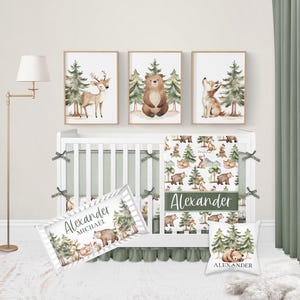 Op de afbeelding: Een kinderkamer set met een witte wieg en groene accenten, met beddengoed met bos thema. De set bevat ingelijste kunstafdrukken van een hert, beer en vos. Een kussen en een decoratieve naambanner zijn ook inbegrepen.